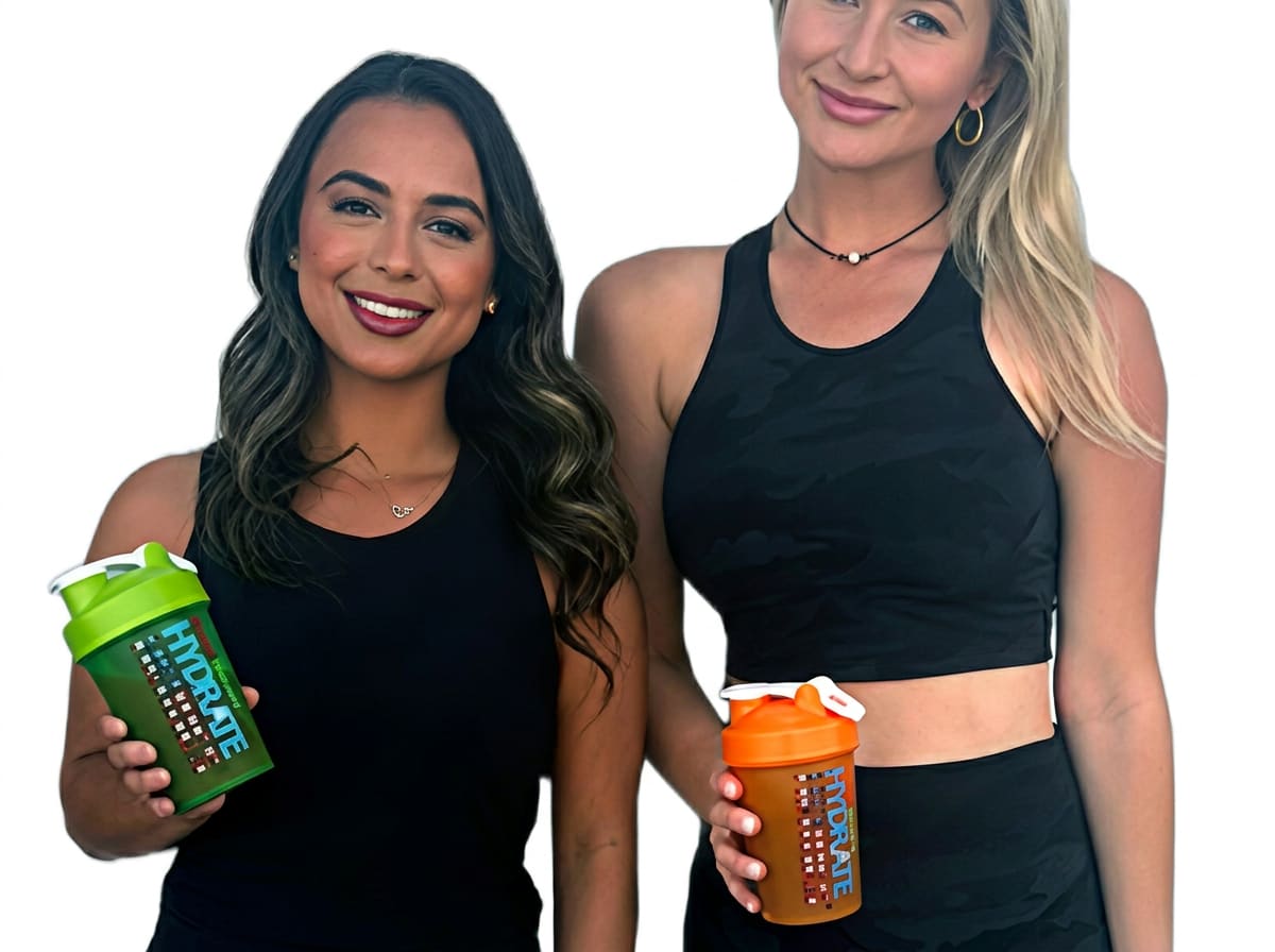Two women holding Hydrate Heroes branded shaker bottles